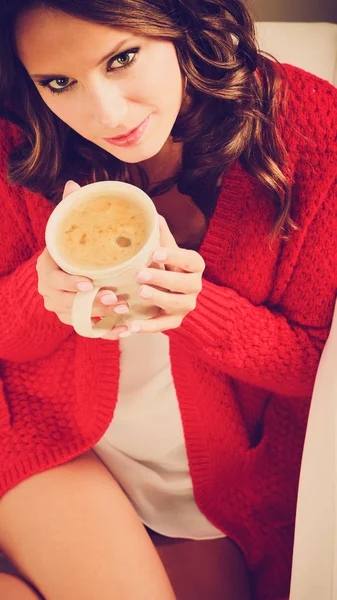 女孩红毛衣持有与咖啡的杯子 — 图库照片