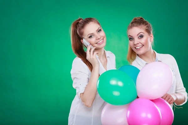 Dwie dziewczyny z telefonu komórkowego i balony — Zdjęcie stockowe