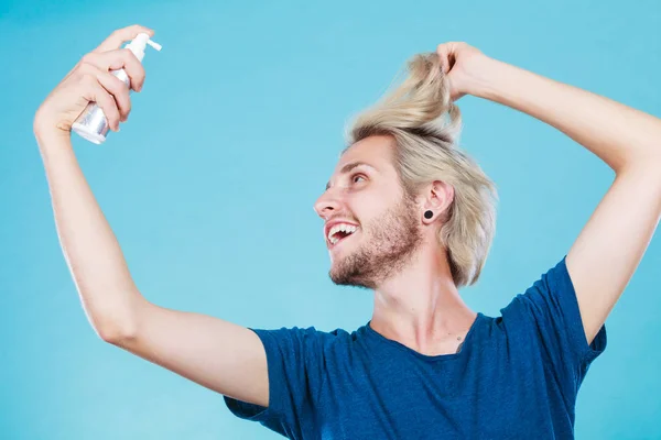 Man applying spray cosmetic to his hair — Stock Photo, Image