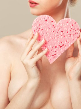 Pembe Kalp sünger elinde tutan çıplak kadın.