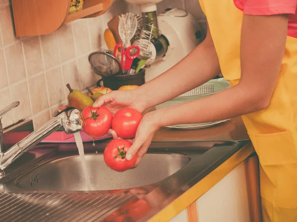 Mujer lavando verduras frescas en la cocina —  Fotos de Stock