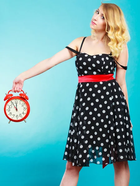 Serious girl with alarm clock on blue. — Stock Photo, Image