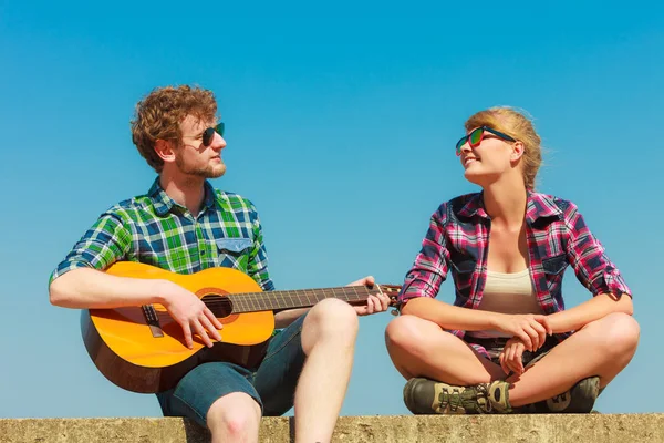 Młody mężczyzna gra na gitarze do jego dziewczyna odkryty — Zdjęcie stockowe