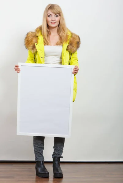 Woman in jacket with blank empty board banner.