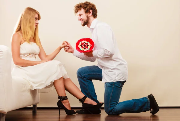 Man giving woman candy bunch flowers. Happy couple — Stock Photo, Image