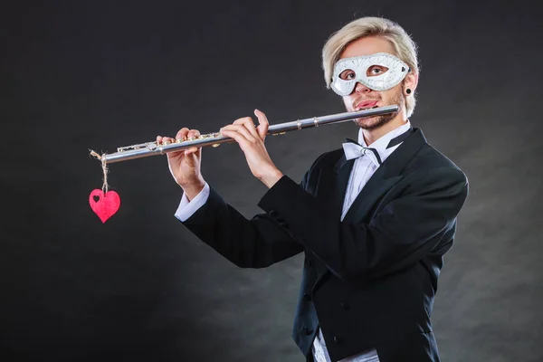 Homem em máscara de carnaval tocando flauta — Fotografia de Stock