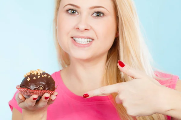 Woman holding chocolate cupcake about to bite — Stock Photo, Image