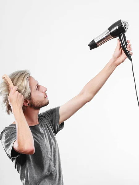 Jovem homem secando o cabelo com secador de cabelo — Fotografia de Stock