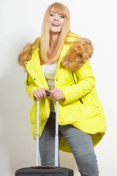 Glückliche junge Frau in warmer Jacke mit Koffer. — Stockfoto