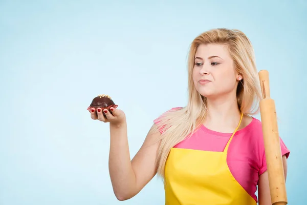 Kvinna som håller cupcake och kavel klädd förkläde — Stockfoto