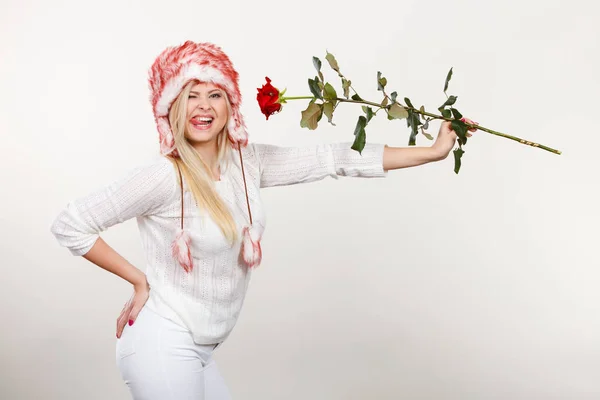 Mulher no inverno chapéu peludo segurando rosa vermelha — Fotografia de Stock