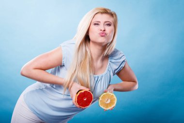 Kırmızı ve yeşil greyfurt tutan kadın