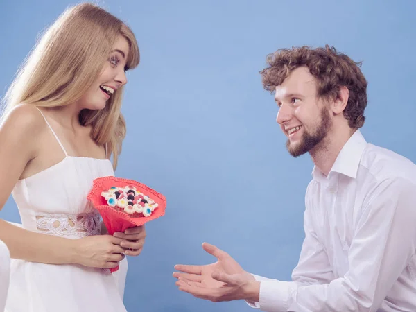 Man vrouw snoep bos bloemen geven. Gelukkige paar — Stockfoto