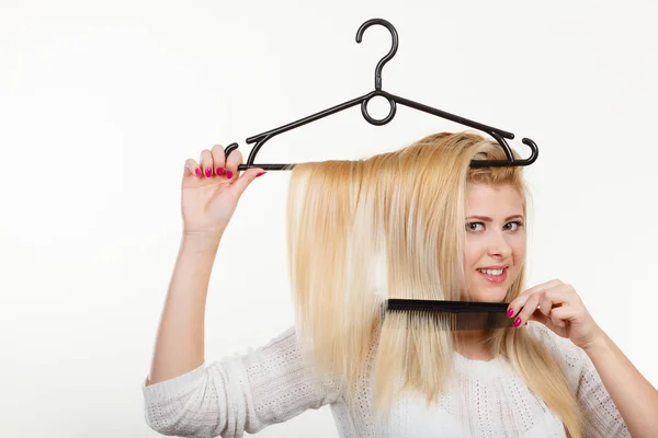 Mulher loira segurando o cabelo no cabide de roupas — Fotografia de Stock