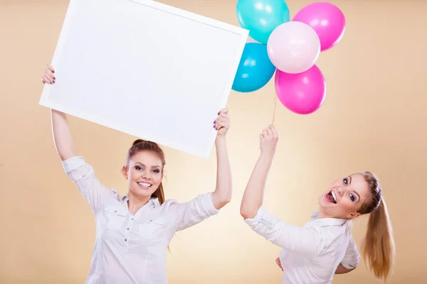 Duas meninas com placa em branco e balões — Fotografia de Stock