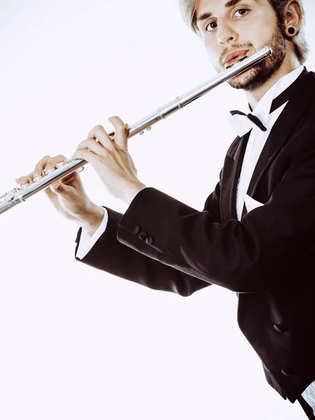 Male flutist wearing tailcoat plays flute — Stock Photo, Image
