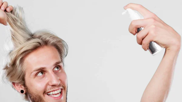 Homem aplicando spray cosmético em seu cabelo — Fotografia de Stock