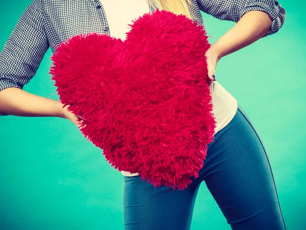 Mujer sosteniendo almohada roja en forma de corazón — Foto de Stock