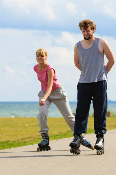 Jóvenes juntos patinando en el parque frente al mar . — Foto de Stock