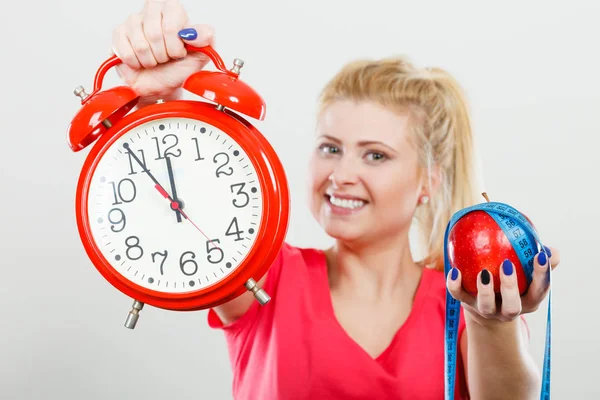 Happy woman holding clock, apple and measuring tape — Stock Photo, Image