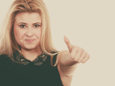 Gülümseyen sarışın kadın hareketi yukarı yapma