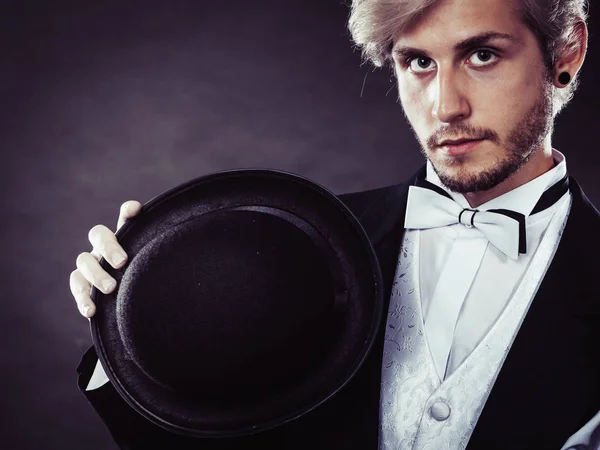 Elegantly dressed man holding black fedora hat — Stock Photo, Image