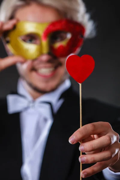 Homem em máscara de carnaval com coração vara símbolo do amor — Fotografia de Stock