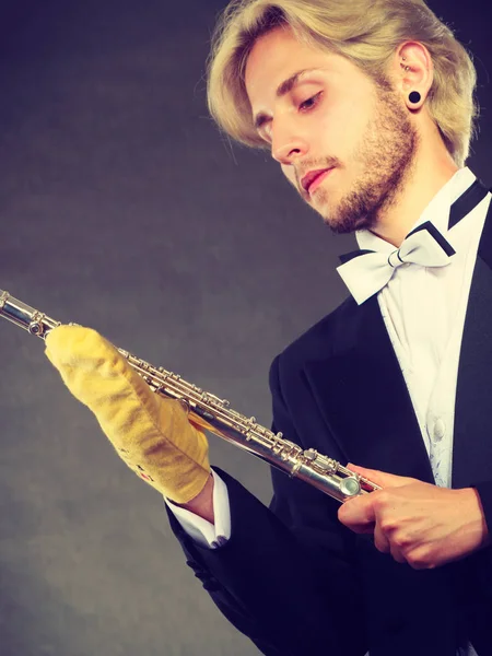 Elegantly dressed musician man cleaning flute — Stock Photo, Image