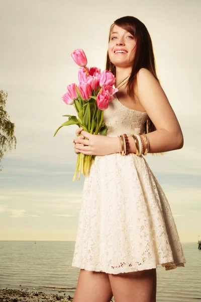 Portrait de femme tenant des fleurs sur la plage — Photo