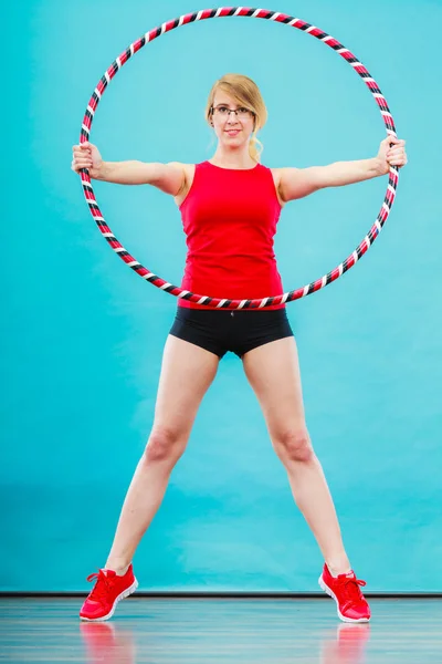 Adatto donna con hula hoop facendo esercizio — Foto Stock