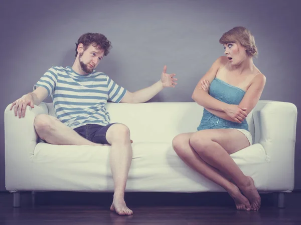Мужчина и женщина в разногласиях сидят на диване — стоковое фото