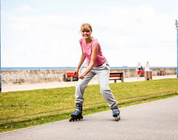 Junge Frauen turnen draußen auf Rollerblades. — Stockfoto