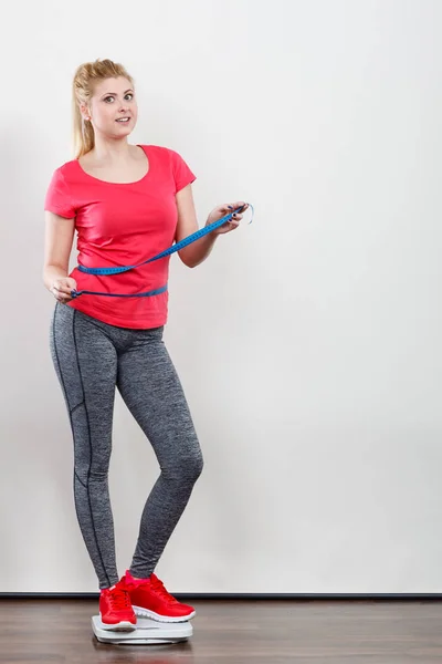 Žena nosí sportovní oblečení stojící na hmotnost stroje — Stock fotografie