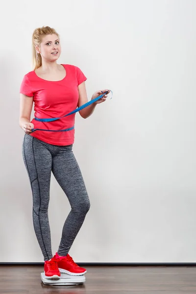 Vrouw het dragen van sportkleding staande op gewicht machine — Stockfoto