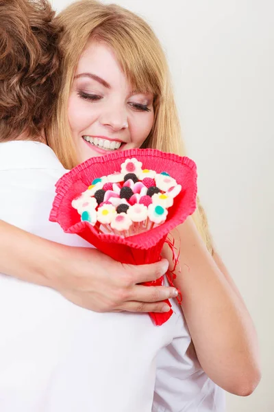 Paar mit Süßigkeiten Strauß Blumen umarmen. Liebe. — Stockfoto