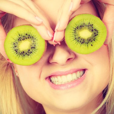 Gözlük gibi yeşil kivi tutan kadın