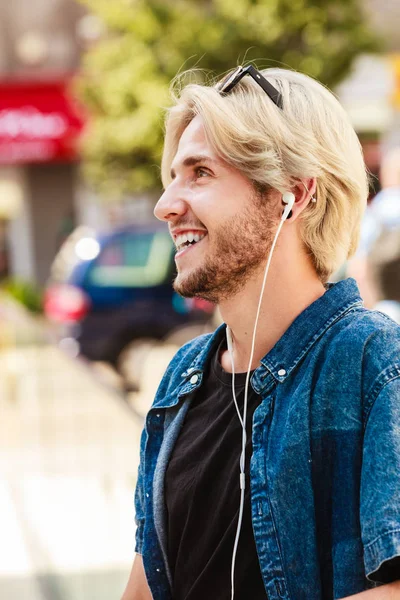 Hipster człowiek stojący na miasto ulica słuchania muzyki — Zdjęcie stockowe