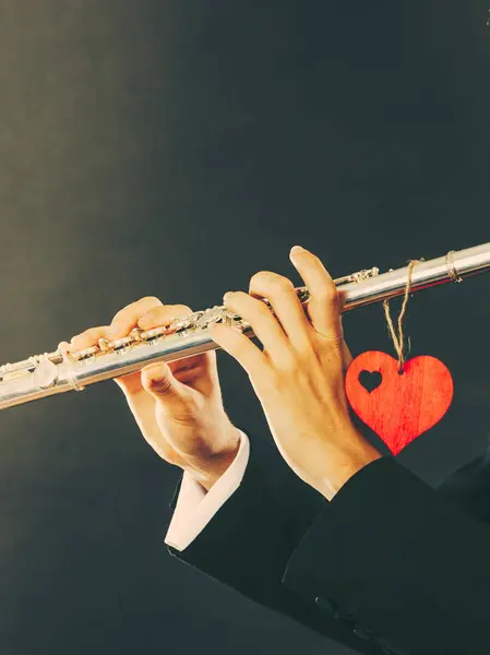 Male flutist with flute and heart. Love melody