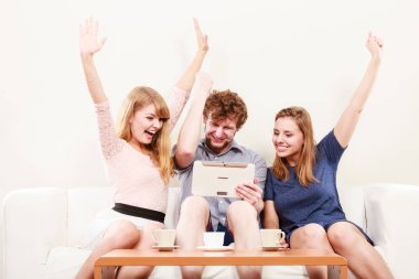 Evde tablet ile başarılı mutlu arkadaşlar.