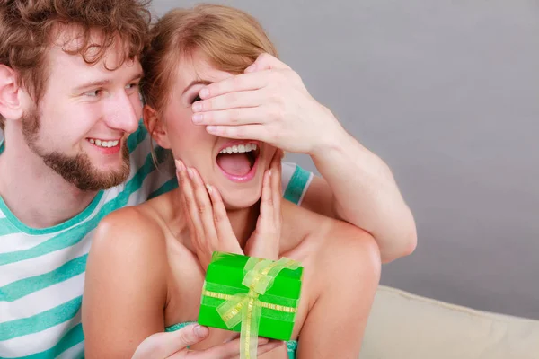 Mladý muž dává ženě dárkové balení — Stock fotografie