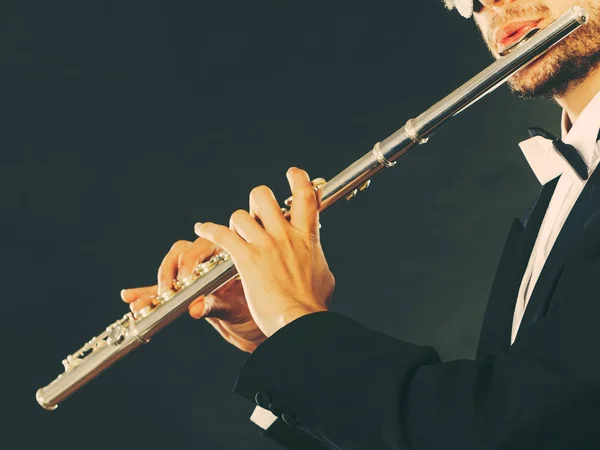 Elegantemente vestido músico masculino tocando flauta — Fotografia de Stock