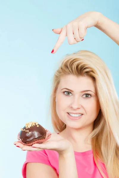 Woman holding chocolate cupcake about to bite — Stock Photo, Image