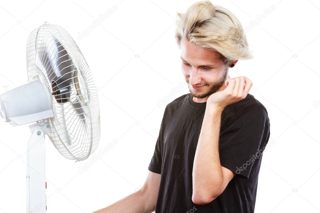 Young man in front of cooling fan
