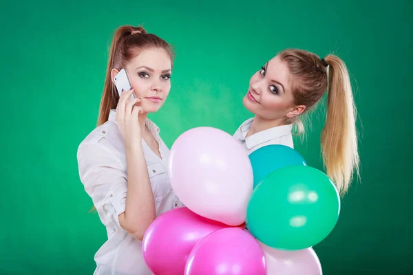 Due ragazze con cellulare e palloncini — Foto Stock