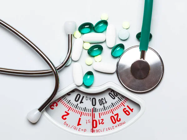 Pillen und Stethoskop auf der Waage. Gesundheitsversorgung — Stockfoto