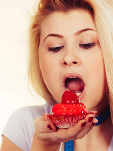 Woman eating sweet strawberry cupcake — Stock Photo, Image