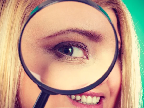 Woman looking through magnifying glass