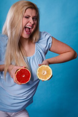 Kırmızı ve yeşil greyfurt tutan kadın
