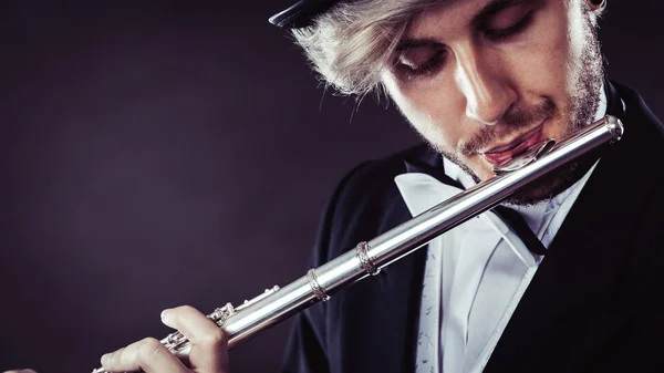 Elegantly dressed male musician playing flute — Stock Photo, Image