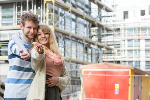 Pareja con llaves en frente de la nueva casa moderna — Foto de Stock